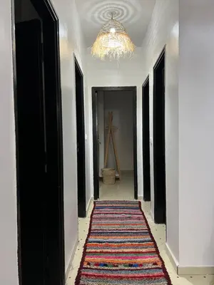 a hallway with a rug on the floor and a chandelier at Aeroport appartement in Marrakech