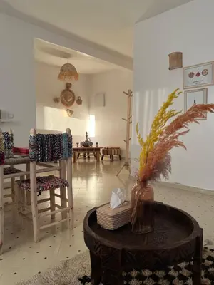 a living room with a table and chairs and a vase at Aeroport appartement in Marrakech
