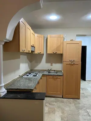 a kitchen with wooden cabinets and a stove top oven at DARNA 34 FACE GARE CTM HIVERNAGE a 10MN DE L'AEROPORT in Marrakech
