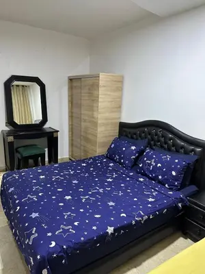 a bedroom with a bed with a blue comforter and a mirror at DARNA 34 FACE GARE CTM HIVERNAGE a 10MN DE L'AEROPORT in Marrakech