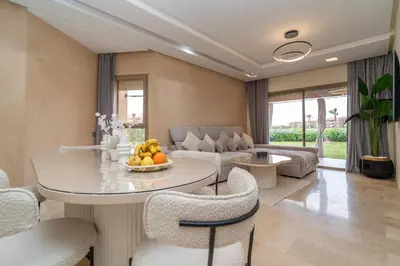 a living room with a table and chairs and a couch at Prestigia agate vue sur golf in Marrakech