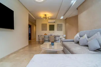 a living room with a couch and a table at Prestigia agate vue sur golf in Marrakech