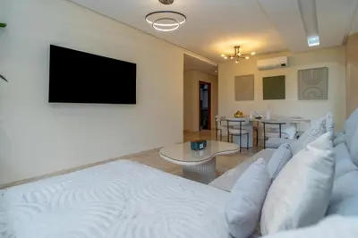 a living room with a couch and a flat screen tv at Prestigia agate vue sur golf in Marrakech