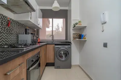 a kitchen with a washing machine and a sink at Prestigia agate vue sur golf in Marrakech