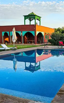 a swimming pool in front of a building at Tente berbère in Marrakech