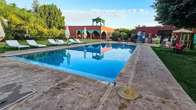 a swimming pool with lounge chairs next to a house at Tente berbère in Marrakech