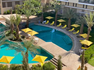 an overhead view of a swimming pool with yellow umbrellas at Luxueux appartement a Marrakech in Marrakech