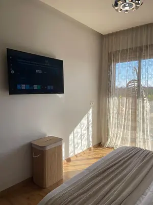a bedroom with a flat screen tv on the wall at Luxueux appartement a Marrakech in Marrakech
