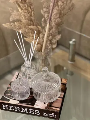 two glass containers on a table with a vase at Luxueux appartement a Marrakech in Marrakech
