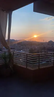 a sunset from a balcony with a view of a city at Kech Aliouni in Marrakech