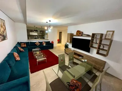 a living room with a blue couch and a tv at Appartement 2 chambres Atr67 Hivernage in Marrakech