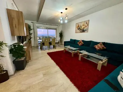 a living room with a blue couch and a red rug at Appartement 2 chambres Atr67 Hivernage in Marrakech