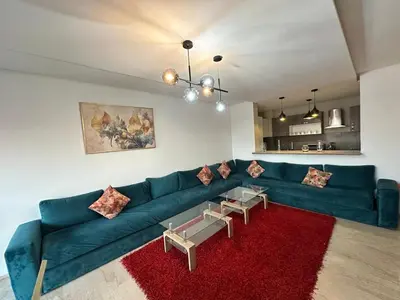 a living room with a blue couch and a red rug at Appartement 2 chambres Atr67 Hivernage in Marrakech