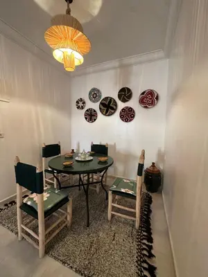 a dining room with a table and chairs and plates on the wall at A flat near the airport in Marrakech