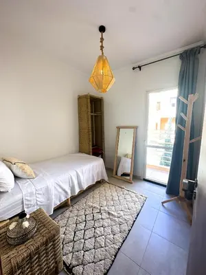 a bedroom with a bed and a mirror on the wall at A flat near the airport in Marrakech