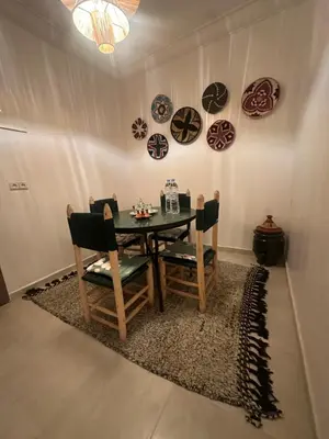 a dining room with a table and chairs and plates on the wall at A flat near the airport in Marrakech