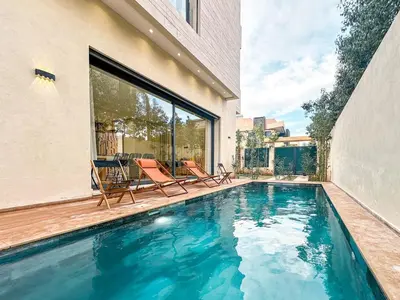 a swimming pool with two chairs and a house at Villa Stayvi 1 Heated Pool Bliss in Marrakech