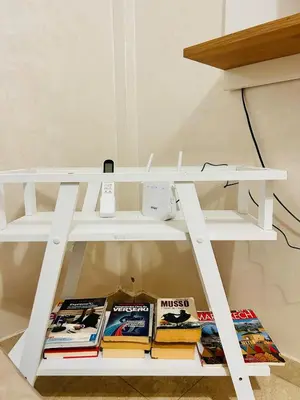 a white book shelf with books on it at Bright downtown apartment in Marrakech