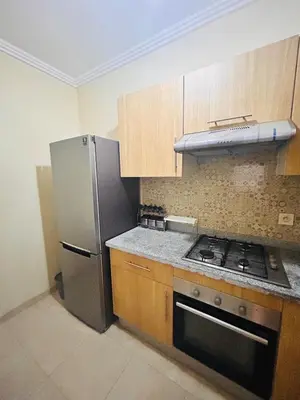 a kitchen with a stove and a refrigerator at Bright downtown apartment in Marrakech