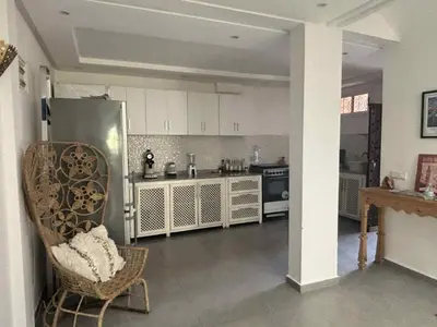 a kitchen with a refrigerator and a chair in a room at RIAD Marrakech zina in Marrakech