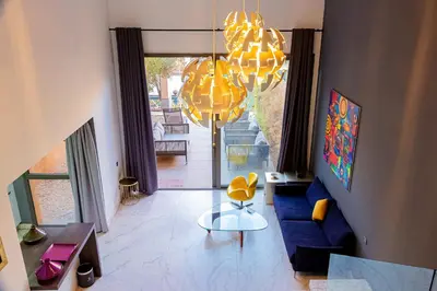 a living room with a blue couch and a chandelier at Atelier Loft Oliver Palm Resort in Marrakech