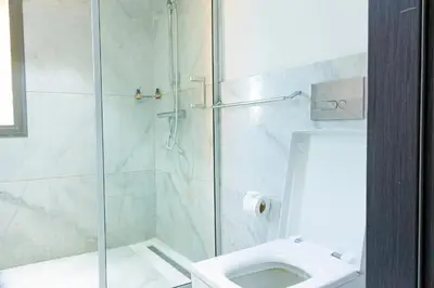 a bathroom with a glass shower and a toilet at Atelier Loft Oliver Palm Resort in Marrakech