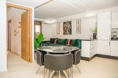 a living room with a green couch and a table at Lux Oasis - Marrakech Center in Marrakech