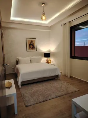 a bedroom with a white bed and a television at Modern apartement in Hivernage in Marrakech