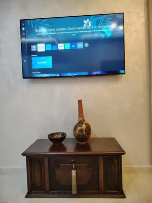 a vase sitting on top of a table with a tv at Modern apartement in Hivernage in Marrakech