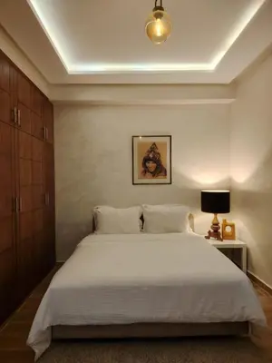 a bedroom with a large white bed and a lamp at Modern apartement in Hivernage in Marrakech