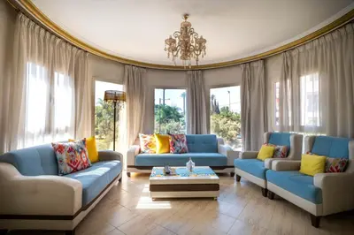 a living room with blue couches and a chandelier at Beautiful Spacious Apartment with Marrakech in Marrakech
