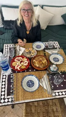 a woman sitting at a table with plates of food at Riad Abrare in Marrakech