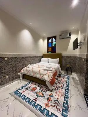 a bedroom with a bed and a rug on the floor at Riad Abrare in Marrakech