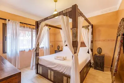 a bedroom with a four poster bed with curtains at New! Apt jacaranda, wifi and parking in Marrakech