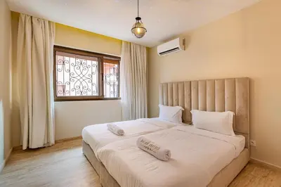 a bedroom with a large white bed with a window at New! Apt jacaranda, wifi and parking in Marrakech