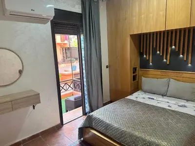a bedroom with a bed and a sliding glass door at Dream stay 5 swimming pools for family in Marrakech