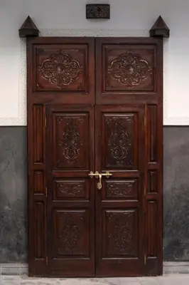 a large wooden door in a building at Riad O'Zeen in Marrakech