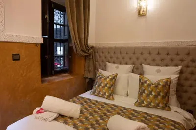 a bedroom with two beds with pillows at Riad O'Zeen in Marrakech