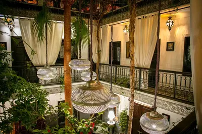 a balcony with a table and chairs and trees at Riad O'Zeen in Marrakech