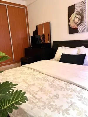 a bedroom with a large bed and a dresser at Appartement Marrakech 2 chambres Residence al Manar in Marrakech