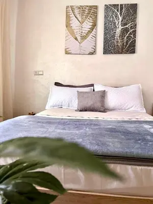 a bedroom with a bed with three pictures on the wall at Appartement Marrakech 2 chambres Residence al Manar in Marrakech