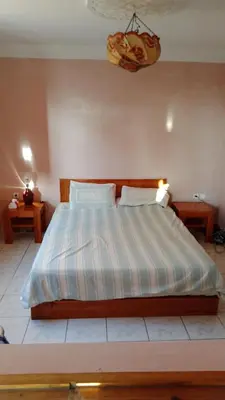 a bedroom with a bed with a striped comforter at John's Place in Chrabli