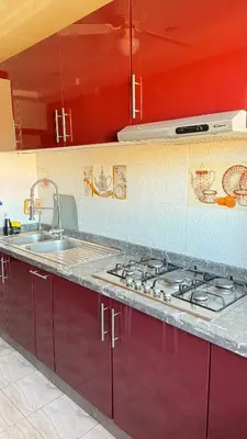 a kitchen with red cabinets and a sink at Appartement, Marrakech cosy & traditionnel in Marrakech