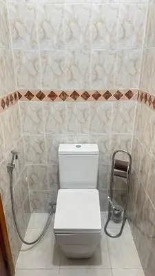 a white toilet in a bathroom with a hose at Appartement, Marrakech cosy & traditionnel in Marrakech
