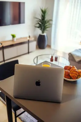 an apple laptop sitting on a table with a plate of food at Livia cosy - Clim, Wifi, Jardin à 10min de l'Aéroport in Marrakech