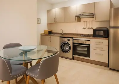 a kitchen with a glass table and chairs in it at Appart Opera Prestige Détente Moderne in Marrakech