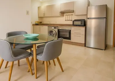 a kitchen with a table and chairs and a refrigerator at Appart Opera Prestige Détente Moderne in Marrakech