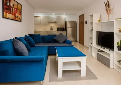 a blue couch and a table in a living room at Appart Opera Prestige Détente Moderne in Marrakech