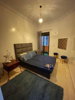 a bedroom with a large bed and a table at appartement à coté des palmeraies in Marrakech