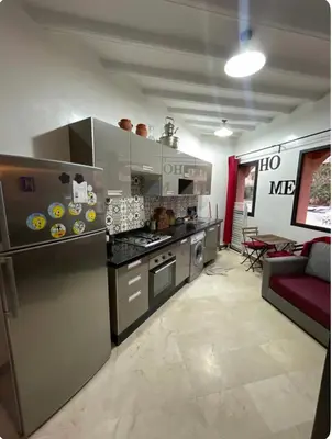 a kitchen with stainless steel appliances and a couch at appartement à coté des palmeraies in Marrakech